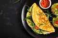 Breakfast. Omelette with tomatoes, cheese, green arugula and toasts with avocado cream