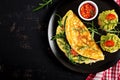 Breakfast. Omelette with tomatoes, cheese, green arugula and toasts with avocado cream