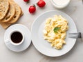 Breakfast with pan-fried scrambled eggs, cup of coffee, tomatoes on white stone background. Omelette, top view Royalty Free Stock Photo