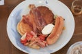 Breakfast pancakes bacon and sausages on wooden table. Homemade Continental breakfast at home kitchen Royalty Free Stock Photo