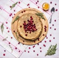 Breakfast with pancakes and honey, berries, cranberries and thyme tea wooden rustic background top view