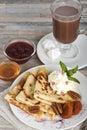 Breakfast. Pancakes, honey, strawberry jam, cream, dried apricots, nuts and hot chocolate or cocoa or coffee