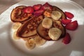 Breakfast pancakes with sliced strawberries and bananas on a white plate Royalty Free Stock Photo