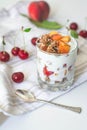 Breakfast parfait with yogurt, granola, peach and sour cherries in a glass. Royalty Free Stock Photo