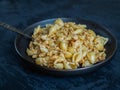 Breakfast with pasta in the form of sea shells and minced chicken meat on a black plate on a dark background, table fork Royalty Free Stock Photo