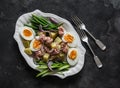 Breakfast plate - boiled eggs, potatoes, string beans, red onion, cucumber, canned tuna salad on a dark background, top view Royalty Free Stock Photo