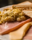 Breakfast plate composed of scrambled egg, toast, ham, and cheese slices Royalty Free Stock Photo