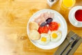 Delicious breakfast with eggs, ham, tomatoes, and pastries served on a wooden table Royalty Free Stock Photo