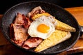 Breakfast plate featuring a freshly fried egg, a slice of bread, and bacon slices Royalty Free Stock Photo