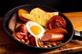 Breakfast plate featuring a freshly fried egg, a slice of bread, and a few sausage links Royalty Free Stock Photo