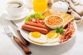 breakfast with plate of fried eggs bacon beans sausages toasts and tomatoes