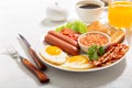 breakfast with plate of fried eggs bacon beans sausages toasts and tomatoes