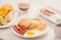 Breakfast plate with pancakes, eggs, bacon and fruit. Royalty Free Stock Photo