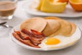 Breakfast plate with pancakes, eggs, bacon and fruit. Royalty Free Stock Photo