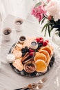 Breakfast platter. Table setting. Pancakes, breakfast sausages, berries, fruits, chocolate spread and coffee. Morning light. White