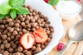 Breakfast pouring milk into corn flakes balls Healthy tasty breakfast chocolate balls with strawberries, raspberries Royalty Free Stock Photo