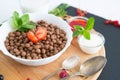 Breakfast pouring milk into corn flakes balls Healthy tasty breakfast chocolate balls with strawberries, raspberries Royalty Free Stock Photo