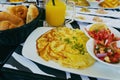 Breakfast in restaurant with omelet, salad, bread and orange juice in instagram style