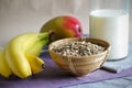 Breakfast with rolled oatmeal, bananas, mango and milk