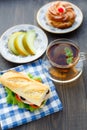 Breakfast with sandwich, tea, cake and melon Royalty Free Stock Photo