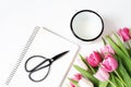 Breakfast scene with mug of milk, vintage black scissors, blank notebook and bouquet of pink tulip flowers on white