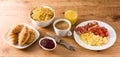 Breakfast with scrambled eggs, bacon, tomatoes,coffee,orange juice ,croissant and corn flakes Royalty Free Stock Photo