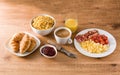 Breakfast with scrambled eggs, bacon, tomatoes,coffee,orange juice ,croissant and corn flakes Royalty Free Stock Photo