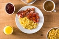 Breakfast with scrambled eggs, bacon, tomatoes,coffee,orange juice ,croissant and corn flakes Royalty Free Stock Photo