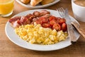 Breakfast with scrambled eggs, bacon, tomatoes,coffee,orange juice ,croissant and corn flakes Royalty Free Stock Photo