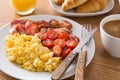 Breakfast with scrambled eggs, bacon, tomatoes,coffee,orange juice ,croissant and corn flakes Royalty Free Stock Photo