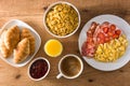 Breakfast with scrambled eggs, bacon, tomatoes,coffee,orange juice ,croissant and corn flakes Royalty Free Stock Photo