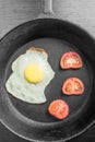 Breakfast with scrambled eggs in a frying pan with vegetables on a dark background, top view Royalty Free Stock Photo