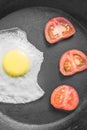 Breakfast with scrambled eggs in a frying pan with vegetables on a dark background, top view Royalty Free Stock Photo