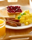 Breakfast with scrambled eggs, sausage links and toast. Royalty Free Stock Photo