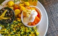 Breakfast scrambled eggs spinach fruit potatoes nicely arranged on plate