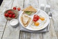 Breakfast of scrambled eggs with tomatoes, pancakes, sandwich. Royalty Free Stock Photo