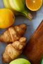 Breakfast served with banana, croissants and fruits, top view, close-up, selective focus Royalty Free Stock Photo