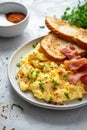 A breakfast serving of scrambled eggs, crispy bacon, and golden toast slices, on a light surface Royalty Free Stock Photo