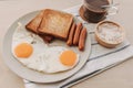 Breakfast set of fried eggs toasted bread sausages and tuna spread. Royalty Free Stock Photo