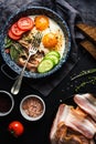 Breakfast set. Pan of fried eggs with bacon, fresh tomato, cucumber, sage and bread Royalty Free Stock Photo