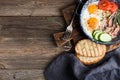 Breakfast set. Pan of fried eggs with bacon, fresh tomato, cucumber, sage and bread on rustic serving board over wooden Royalty Free Stock Photo