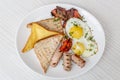 Breakfast setting with fried eggs, bacon, muesli, croissants and juice. Royalty Free Stock Photo