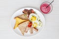 Breakfast setting with fried eggs, bacon, muesli, croissants and juice. Royalty Free Stock Photo