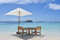 Breakfast setup at the beach in the ocean at the luxury resort at the tropical island with table and chairs Royalty Free Stock Photo