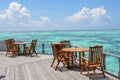 Breakfast setup with wooden tables and chairs near the ocean Royalty Free Stock Photo