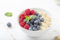 Breakfast smoothie bowl with granola, fresh raspberries, blueberries and mint on white background. Healthy food. Royalty Free Stock Photo