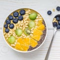 Breakfast smoothie bowl with matcha green tea, kiwi, banana and almond milk, topped with berries, fruits, nuts and seeds, top view Royalty Free Stock Photo