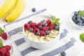 Breakfast smoothie with granola, yogurt, fresh raspberries, blueberries, bananas, coconut flakes, Chia seeds and mint. Royalty Free Stock Photo