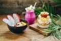 Breakfast Smoothie, Muesli with yoghurt and tropical fruit at brown background and smoothie bowl at wooden background Royalty Free Stock Photo