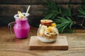 Breakfast Smoothie and Muesli with yoghurt and tropical fruit at brown background Royalty Free Stock Photo